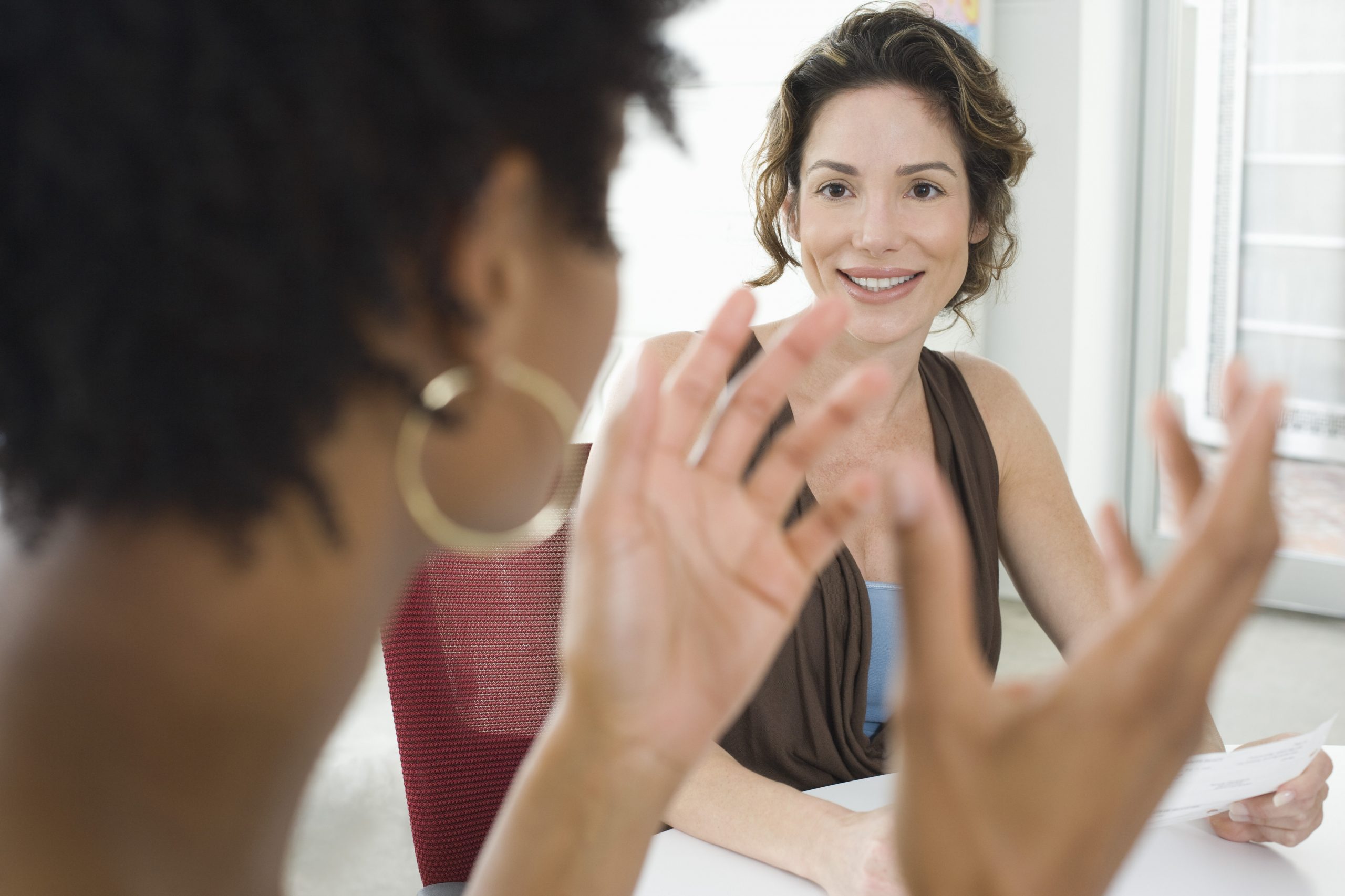 Two mid-adult office workers talking